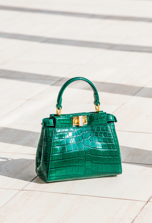 Green Leather Handbag on White Floor Tiles